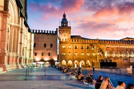 Photo of Italy Piazza Maggiore in Bologna old town tower of town hall with big clock and blue sky on background, antique buildings terracotta galleries.