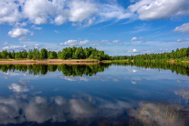 Photo of  Ivalo: Panorama view of pure rural Finnish nature with calm lake water, cloud reflections.