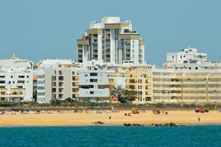 photo of an aerial view of wide sandy beach in touristic resorts of Quarteira and Vilamoura, Algarve, Portugal.