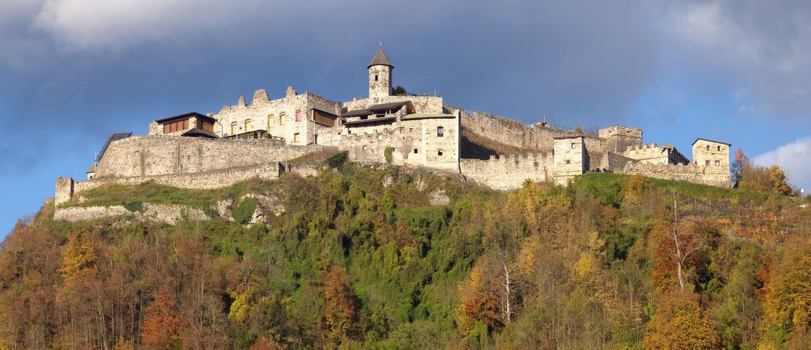 The old medieval castle of Landskron in Villach/Austria located on top of a hill surrounded by a forest.