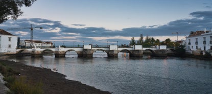 Photo of aerial cityscape of beautiful Tavira with roman bridge over Gilao river in the evening, Algarve, Portugal.