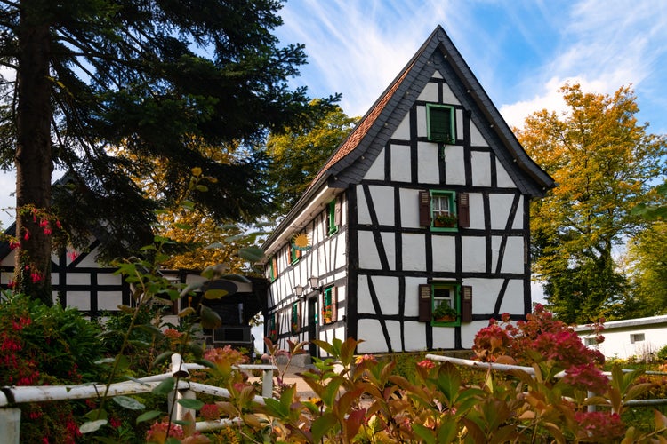 photo of view of Historic truss house and monument in Rhine Valley near Bonn and Königswinter Germany on “Drachenfels“. Traditional architecture with black and white half timbering in idyllic garden in autumn season.