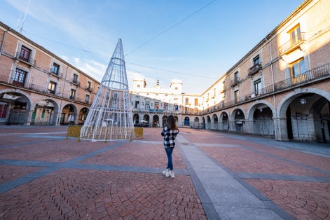 photo of view of Caucasian woman, back view, Avila's winter. Casual elegance, historic charm, exploration delight.