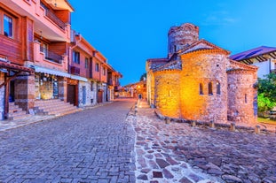 Photo of Saint Anastasia Island in Burgas bay, Black Sea, Bulgaria. Lighthouse tower and old wooden buildings on rocky coast.