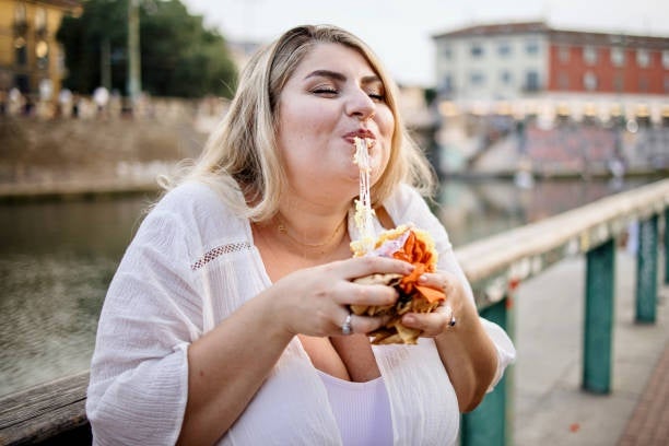 A woman enjoying a bite of a crispy Arancini.jpg