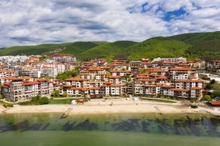 Photo of Saint Anastasia Island in Burgas bay, Black Sea, Bulgaria. Lighthouse tower and old wooden buildings on rocky coast.