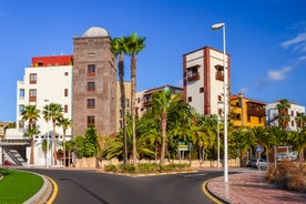 photo of aerial shot of Costa Adeje area, South Tenerife, Spain. Captured at golden hour, warm and vivid sunset colors. Luxury hotels, villas and restaurants behind the beach.