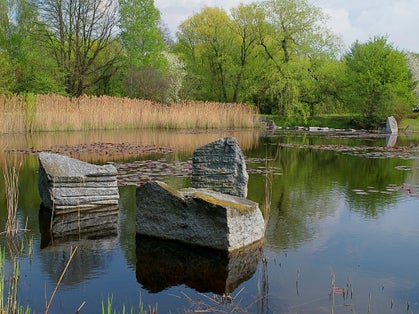 Stones in the pond. Lodz, Poland - April 28, 2015 Stones reflected in the pond in the Botanical Garden in Lodz.