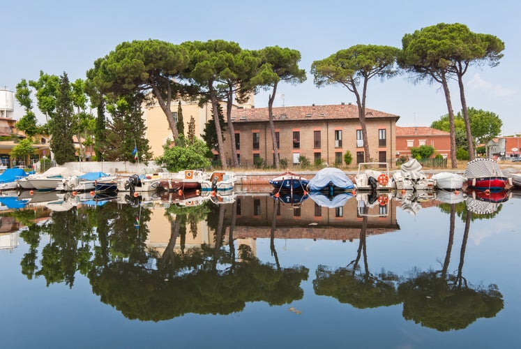 Photo of Cervia's canal, where the Salt Museum is located, with reflections on the water, Italy.