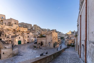 Photo of panoramic view of the ancient town of Matera (Sassi di Matera), European Capital of Culture 2019, in beautiful golden morning light with blue sky and clouds, Basilicata, southern Italy.