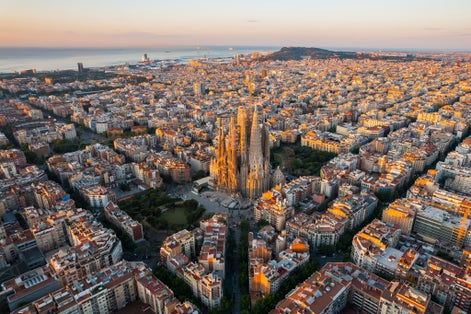 Photo of aerial view of Barcelona Eixample residential district and Sagrada Familia Basilica at sunrise.