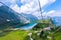 photo of breathtaking view of a serene lake nestled atop Mount Titlis. The lake itself is calm and tranquil, with clear, still waters that reflect the surrounding mountains and sky in Switzerland.