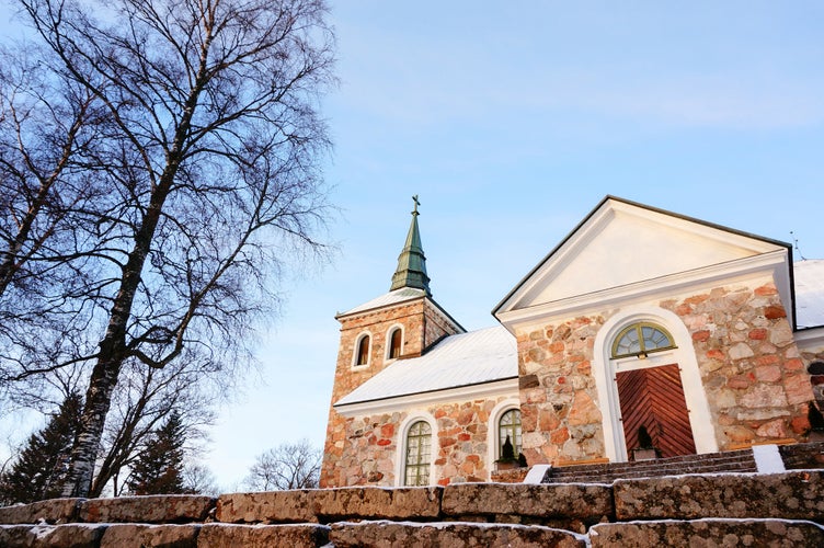 Beautiful Uskela Church (Uskelan kirkko) in winter and sunset lighting on building. It was completed in 1832. It was built of stone and is one-nave long church. Salo, the province of Western Finland