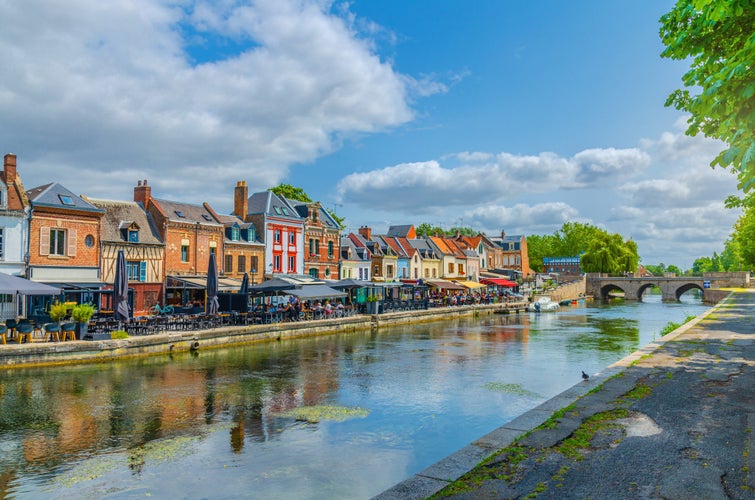 Amiens cityscape old town, promenade Quai Belu of Somme river with restaurants, traditional houses and Pont du Cange stone bridge in historical city centre, Hauts-de-France Region, Northern France