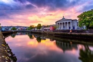 Photo of Colorful row houses with towering cathedral in background in the port town of Cobh, County Cork, Ireland.