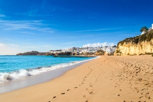 Photo of wide sandy beach in white city of Albufeira, Algarve, Portugal.