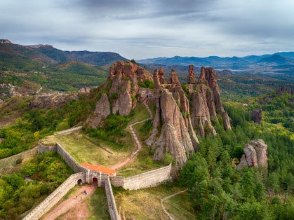 Photo of aerial shot of beautiful landscape with bizarre rock formations. Stone stairs leading to the amazing rock formations and walls of a medieval fortress in Belogradchik, northwest Bulgaria.