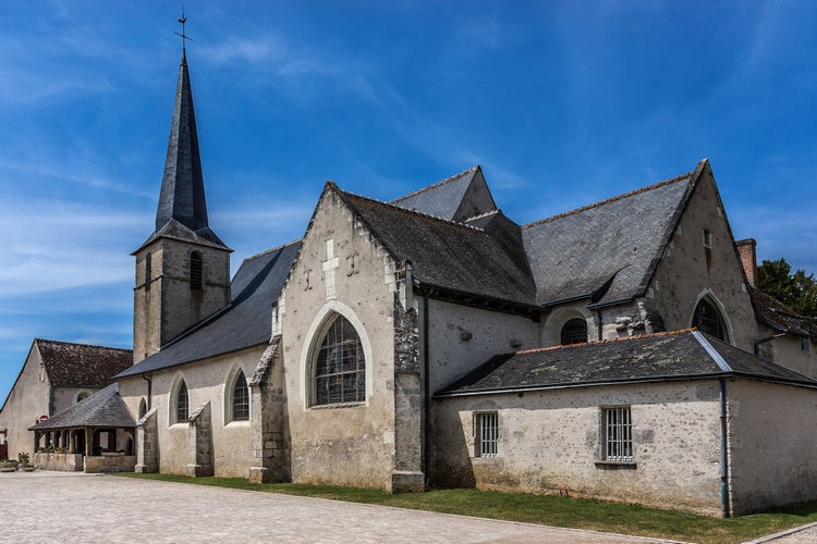 Photo of Lovely little 12th century church of Saint Etienne opposite the entrance to Chateau de Cheverny. Itâ??s surrounded by a timber gallery forming a porch. Cheverny village, France.