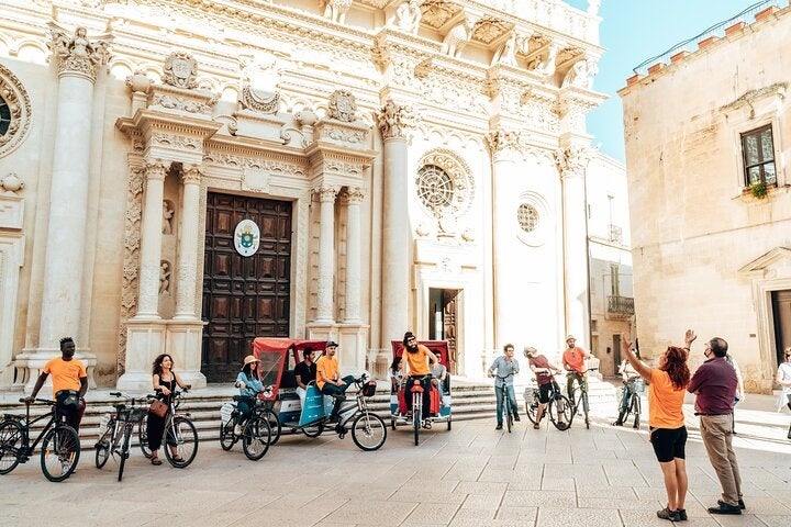 Tourists on a bike tour in front of Lecce Cathedral in Italy’s historic city center on a sunny day..jpg