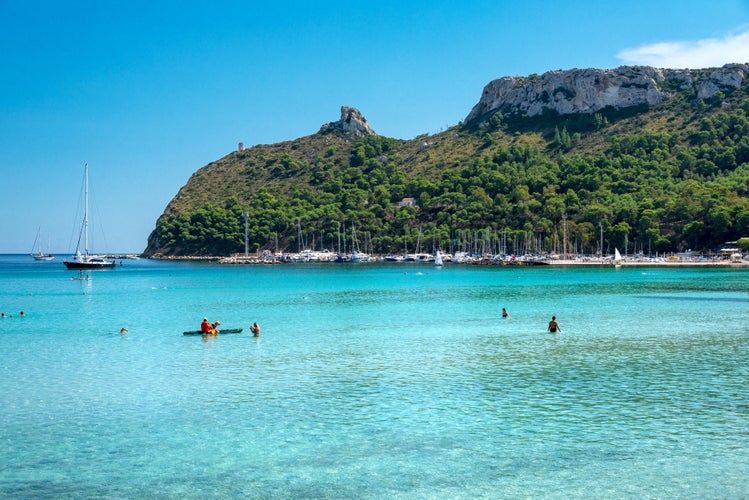 Poetto beach, crystal clear water and the famous Sella del Diavolo, Cagliari, Sardinia, Italy.