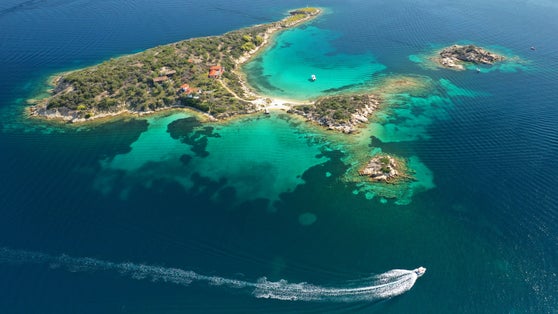 Photo of aerial drone panoramic view iconic small islet of Peristeri with crystal clear turquoise sea near Diaporos island, North Greece.