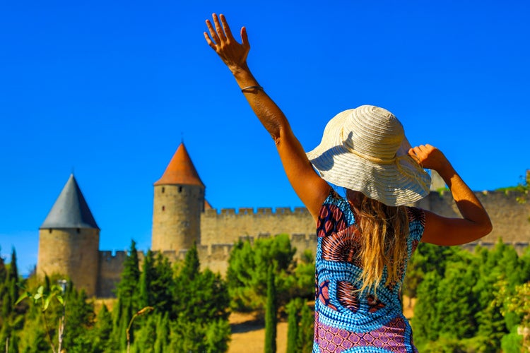 Photo of happy woman visiting Castle of Carcassonne in France.