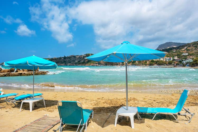 Photo of sun loungers and parasols on beautiful beach of Almyrida ,Crete, Greece.