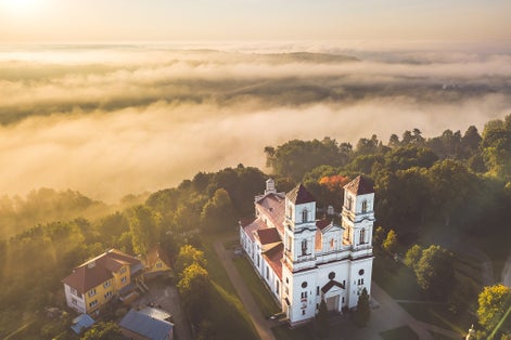 photo of raudondvaris church in the foggy morning, drone aerial view. Raudondvaris is a village in kaunas district, Lithuania.