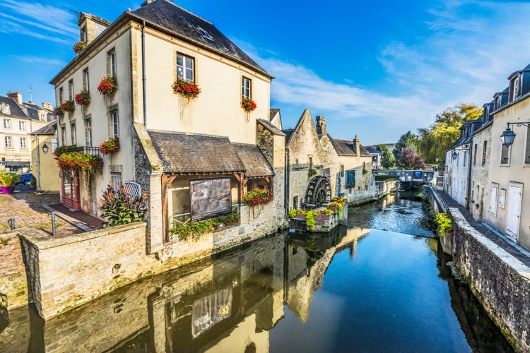 Photo of colorful old buildings, Aure river reflection, Bayeux, Normandy, France.