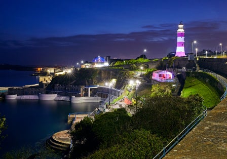 Photo of Seascape of Plymouth Hoe and Smeaton's Tower lighthouse illuminated at night, UK.