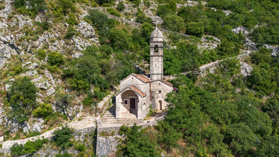 Photo of Aerial view of the Church of Our Lady of Remedy, perched on the slope of St. John Mountain above the old town of Kotor in Montenegro.