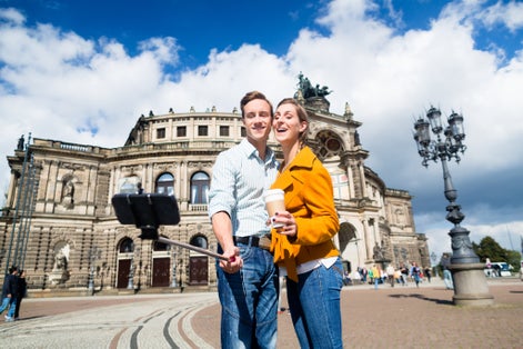 photo of view of Tourist couple at Semperoper in Dresden taking selfie with phone on stick,Saxony  germany.