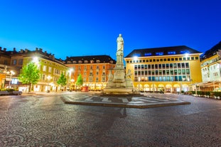 Photo of Italy Piazza Maggiore in Bologna old town tower of town hall with big clock and blue sky on background, antique buildings terracotta galleries.