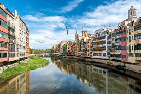 Photo of colorful yellow and orange houses and Eiffel Bridge, Old fish stalls, reflected in water river Onyar, in Girona, Catalonia, Spain.