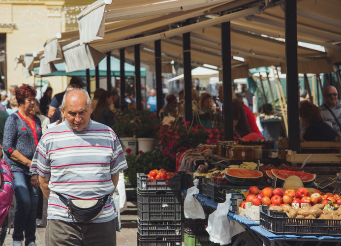 Photo of  Farmer's market in central Kosice, with people exploring the stalls that are packed with fruit and vegetables.