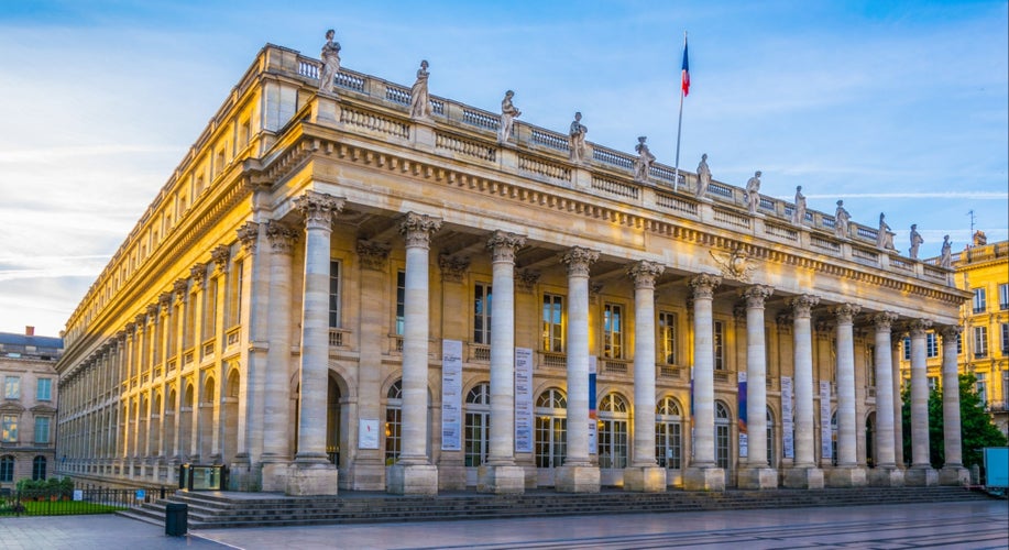 Grand Theatre de Bordeaux with neoclassical columns and rooftop statues illuminated by golden evening light..jpg