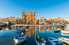 Photo of Msida Marina boat and church reflection into water, Malta.