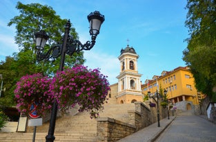 Photo of Saint Anastasia Island in Burgas bay, Black Sea, Bulgaria. Lighthouse tower and old wooden buildings on rocky coast.