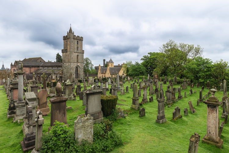 Photo of Cemetery of the Holy Rude Church in Stirling, Scotland, its ancient gravestones dotting the lush greenery, evoking a sense of history and serenity.