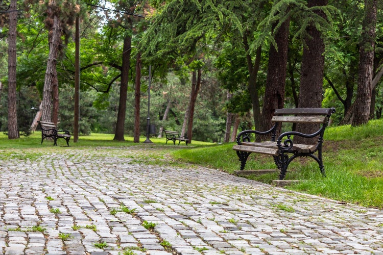 A Stone-paved Pedestrian Path With Empty Benches Along Edge in Public Park in Niš, Serbia