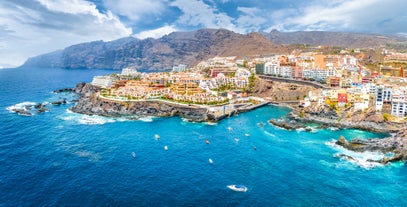 Photo of aerial view with Puerto de la Cruz, in background Teide volcano, Tenerife island, Spain.