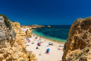 photo of an aerial view of wide sandy beach in touristic resorts of Quarteira and Vilamoura, Algarve, Portugal.