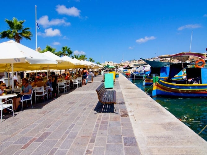 MARSAXLOKK, MALTA -  Tourists relaxing at a pavement cafes along the waterfront, Marsaxlokk, Malta, Europe, 