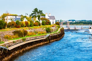 Photo of Colorful row houses with towering cathedral in background in the port town of Cobh, County Cork, Ireland.