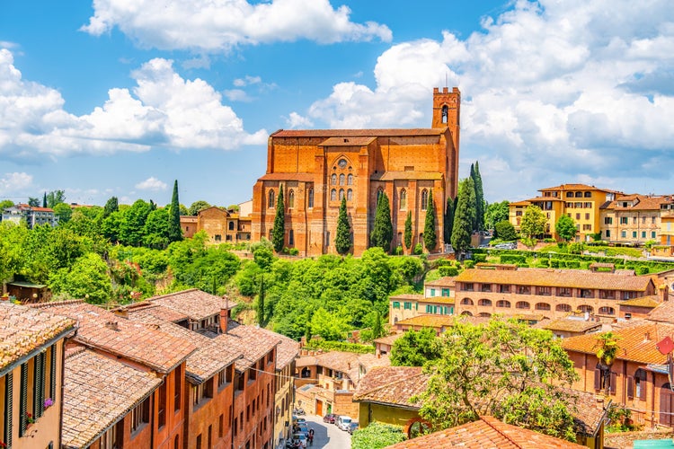 photo of view of Siena, medieval town in Tuscany, with view of the Dome Bell Tower of Siena Cathedral, Mangia Tower and Basilica of San Domenico, Italy