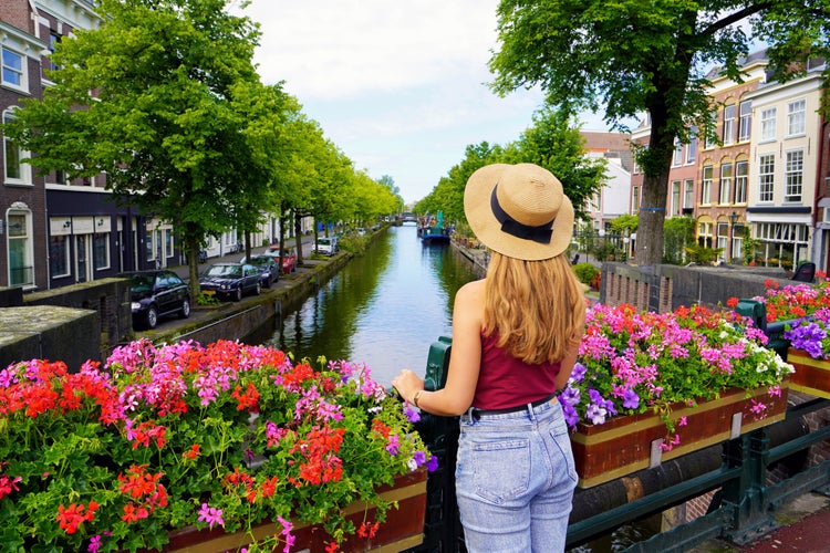 Tourism in Holland. Back view of beautiful fashion girl between flower pots in The Hague, Netherlands.