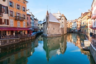 photo of Annecy city center panoramic aerial view with the old town, castle, Thiou river and mountains surrounding the lake, beautiful summer vacation tourism destination in France, Europe.