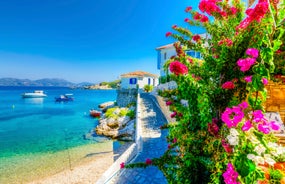 Photo of aerial view of Pythagorio port with colourful houses and blue sea, Samos island, Greece.