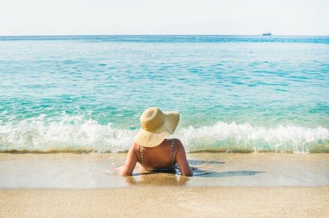 Photo of tourist woman enjoying clear blue waters of Mediterranean sea at Cleopatra beach, Alanya, Turkey.