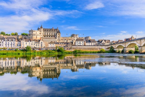 photo of view of Amboise, France. The walled town and Chateau of Amboise reflected in the River Loire.